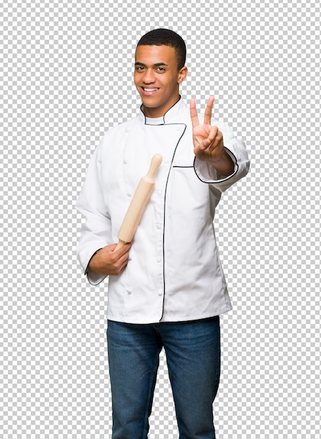 Young afro american chef man smiling and showing victory sign