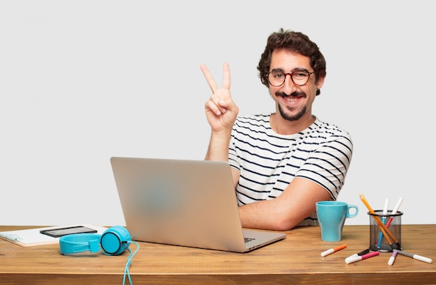 Молодой бородатый графический дизайнер с ноутбуком, улыбаясь и глядя удовлетворены и счастливы