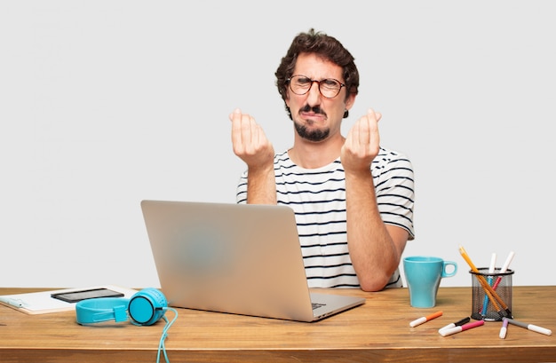 young bearded graphic designer with a laptop looking sad and worried, absolutely empty-handed, broke