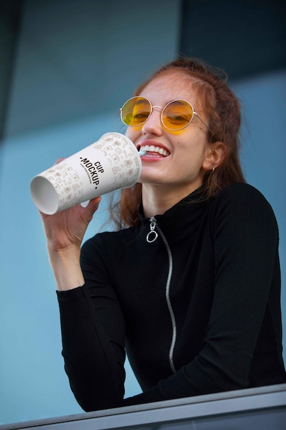 PSD giovane e bella donna che beve dalla tazza mockup