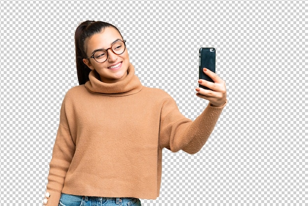 Young beauty woman over isolated chroma key background making a selfie