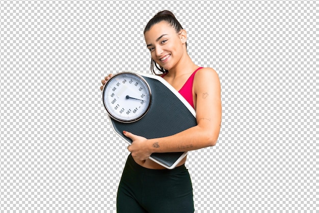 Young beauty woman over isolated chroma key background with weighing machine