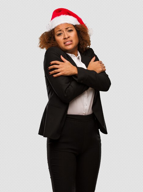 PSD young black businesswoman wearing a christmas santa hat going cold due to low temperature