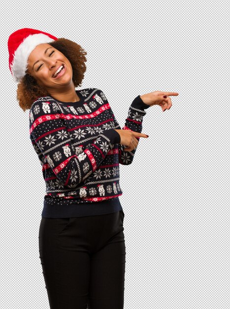 PSD young black woman in a trendy christmas sweater with print pointing to the side with finger