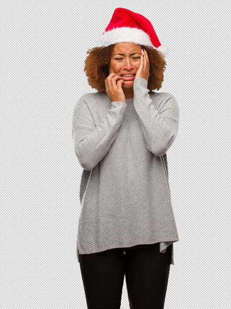 PSD young black woman wearing a santa hat desperate and sad