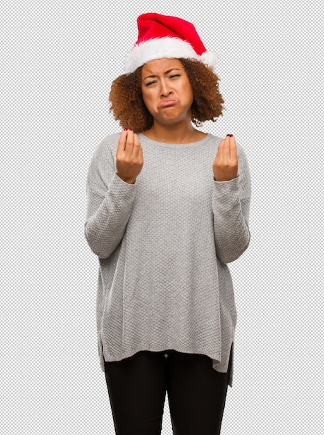 PSD young black woman wearing a santa hat doing a gesture of need