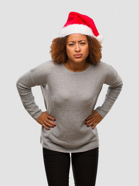 Young black woman wearing a santa hat scolding someone very angry