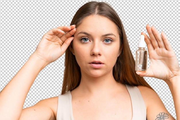 Young blonde woman over isolated chroma key background holding a serum Close up portrait