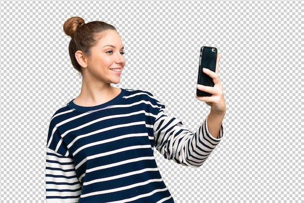 young blonde woman over isolated chroma key background making a selfie