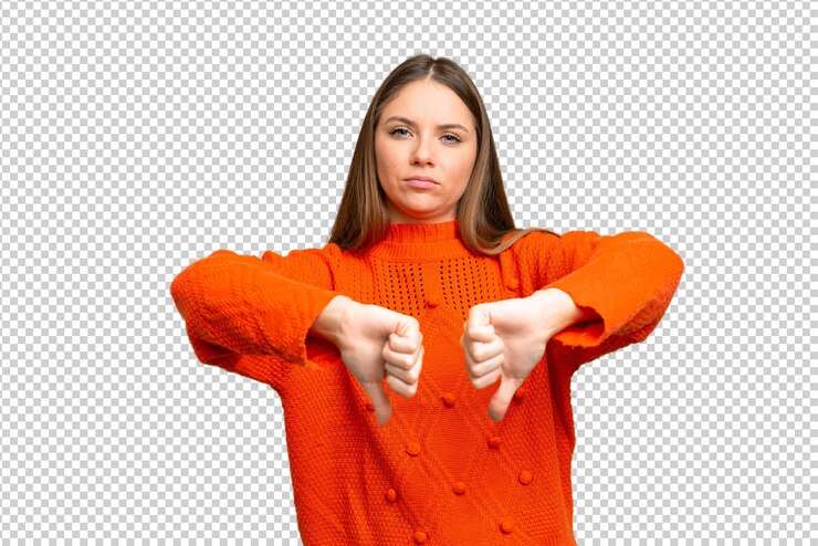 PSD young blonde woman over isolated chroma key background showing thumb down with two hands