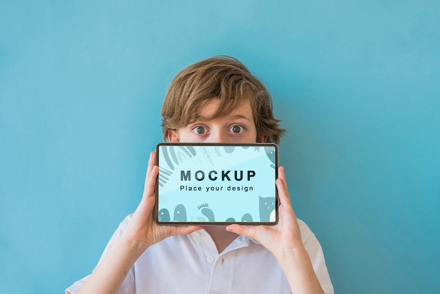 Young boy holding phone with mock-up