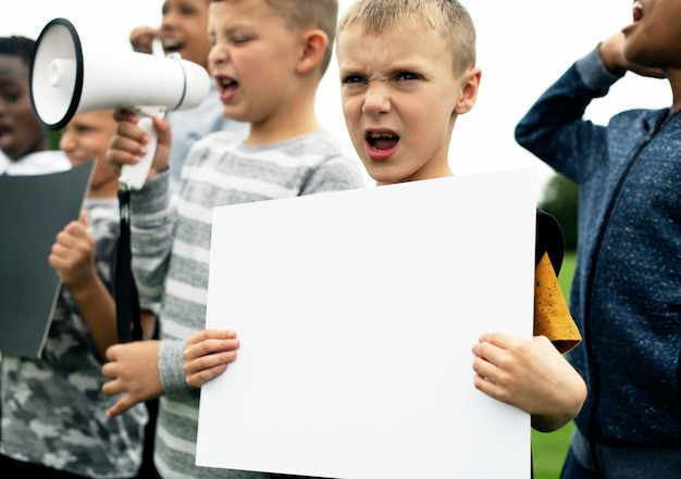 PSD young boy showing a blank paper in a protest