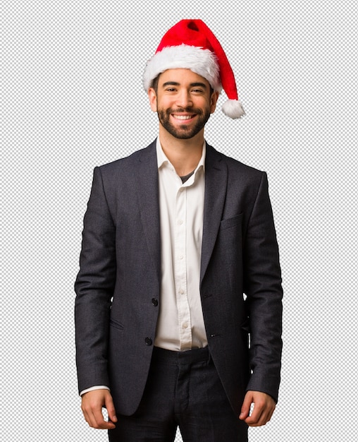 Young business man wearing santa hat cheerful with a big smile