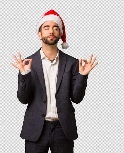 PSD young business man wearing santa hat performing yoga