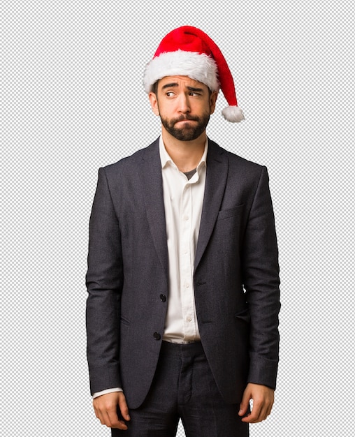 Young business man wearing santa hat thinking about an idea