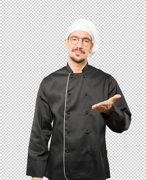 Young chef waving with his hand