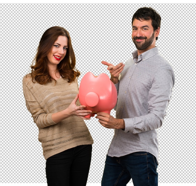 PSD young couple holding a piggybank