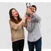 PSD young couple holding a trophy