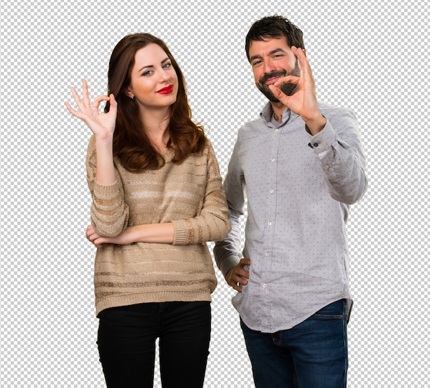 Young couple making OK sign