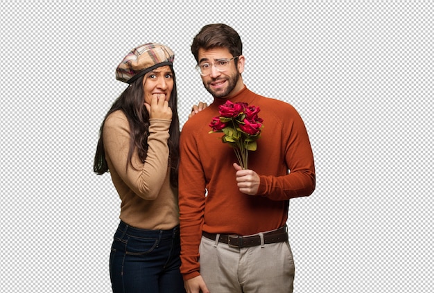 Young couple in valentines day biting nails, nervous and very anxious