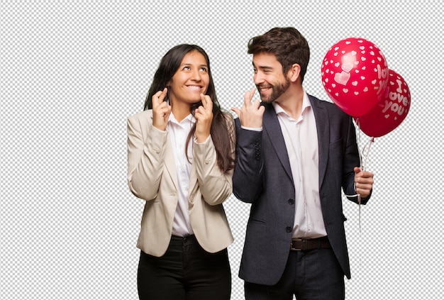 PSD young couple in valentines day crossing fingers for having luck