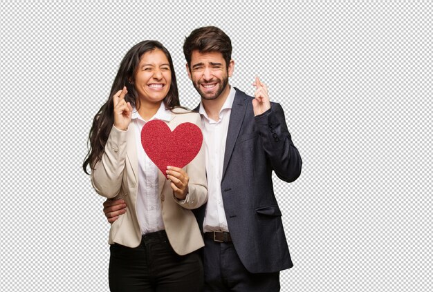 Young couple in valentines day crossing fingers for having luck