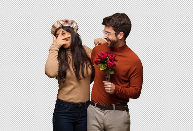 Young couple in valentines day embarrassed and laughing at the same time