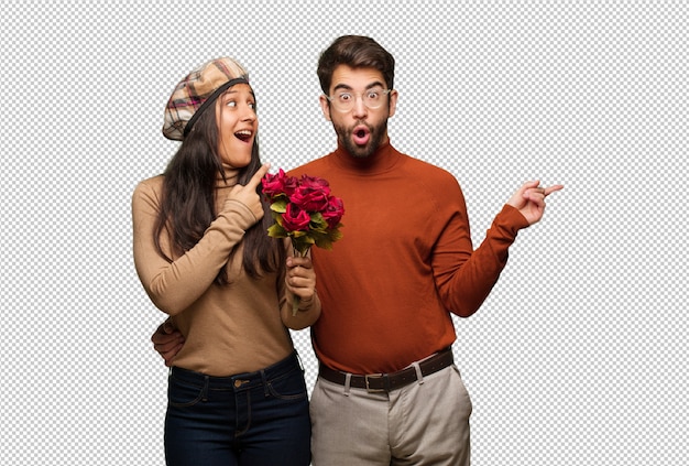 PSD young couple in valentines day pointing to the side