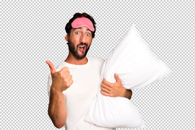 PSD young crazy bearded and expressive man wearing pajamas and eye mask and with a pillow