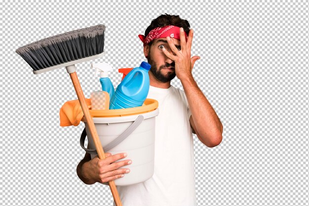 Young crazy bearded and expressive man with clean products housekeeper concept