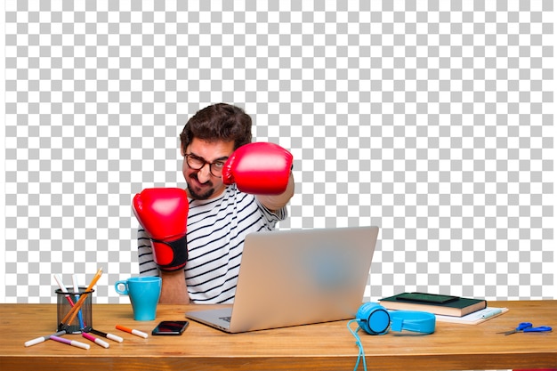 Young crazy graphic designer on a desk with a laptop and wearing boxing gloves