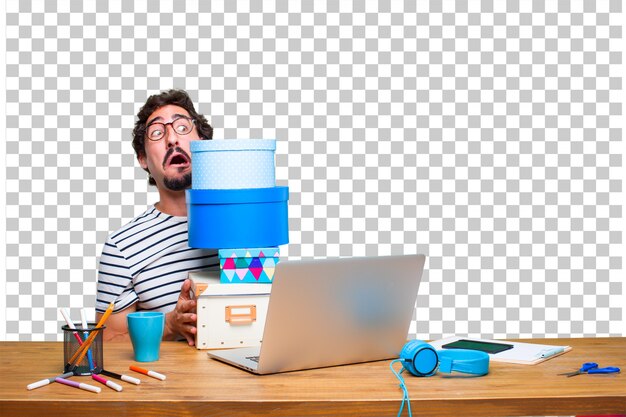 Young crazy graphic designer on a desk with a laptop and with gift box concept