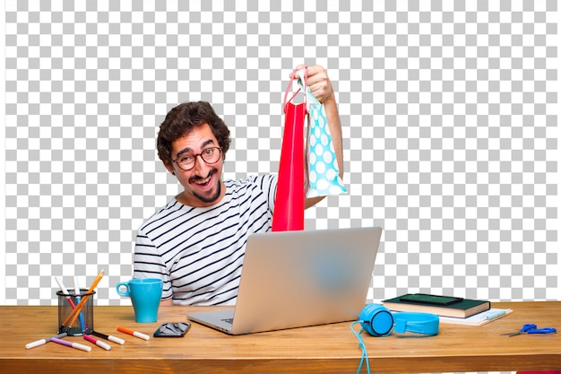 PSD young crazy graphic designer on a desk with a laptop and with shopping bags