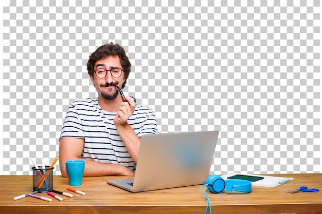 Young crazy graphic designer on a desk with a laptop and with a smoke vintage pipe