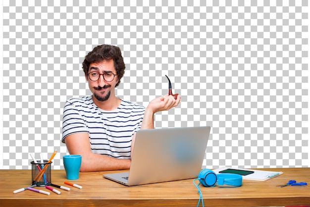 Young crazy graphic designer on a desk with a laptop and with a smoke vintage pipe