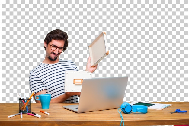 Young crazy graphic designer on a desk with a laptop and with a vintage box