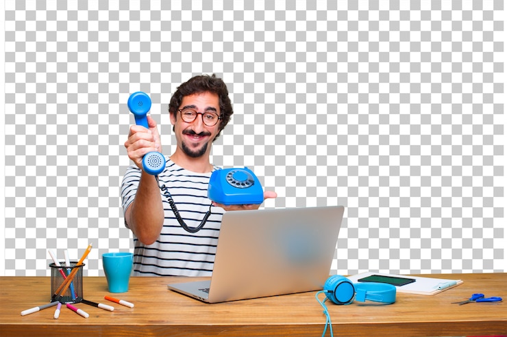 PSD young crazy graphic designer on a desk with a laptop and with a vintage telephone