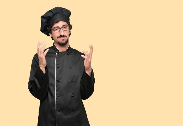 young crazy man as a chef looking stressed and frustrated