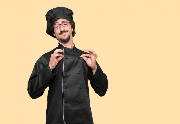 young crazy man as a chef with a proud, happy and confident expression