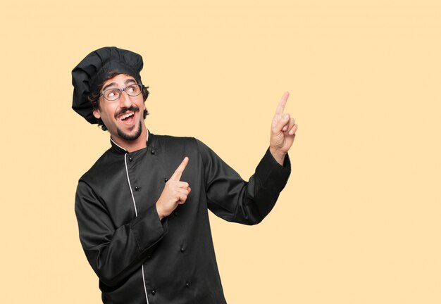 young crazy man as a chef gesturing victory, with a happy, proud and satisfied look on face