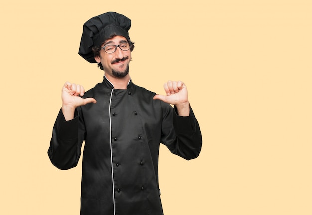 young crazy man as a chef with a proud, happy and confident expression