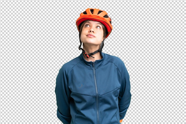 young cyclist girl over isolated chroma key background and looking up