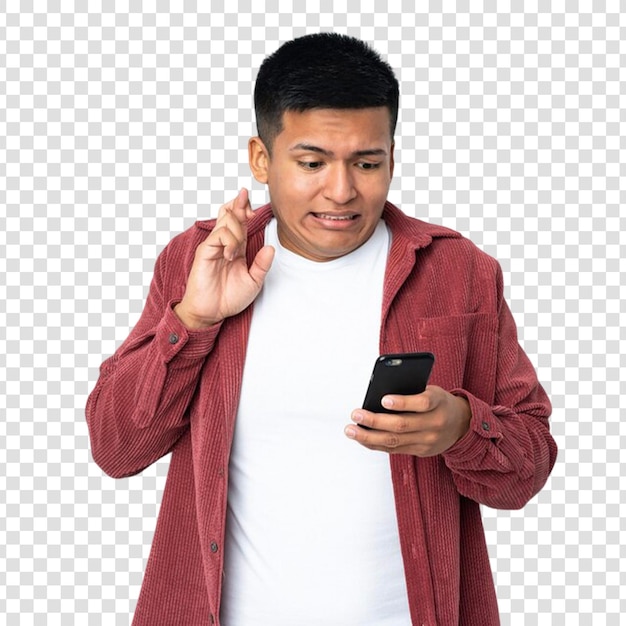 young ecuadorian man isolated on transparent background using mobile phone with fingers crossing