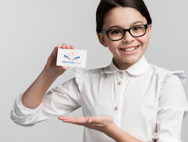 PSD young girl holding business card mock-up