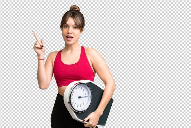 Young girl over isolated chroma key background with weighing machine