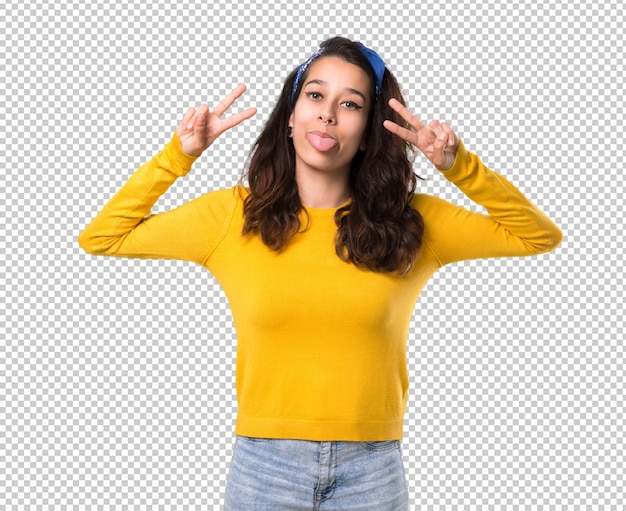 Young girl with yellow sweater and blue bandana on her head showing tongue