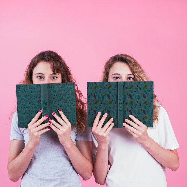PSD young girls holding book cover mockup