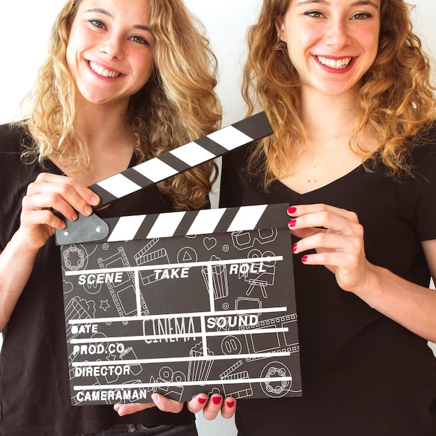 PSD young girls holding clapperboard mockup