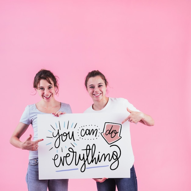 PSD young girls holding white board mockup