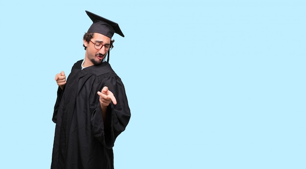young graduated man smiling and dancing to fun, lively disco music